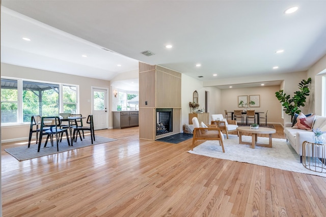 living area with a wealth of natural light, visible vents, recessed lighting, and light wood-type flooring
