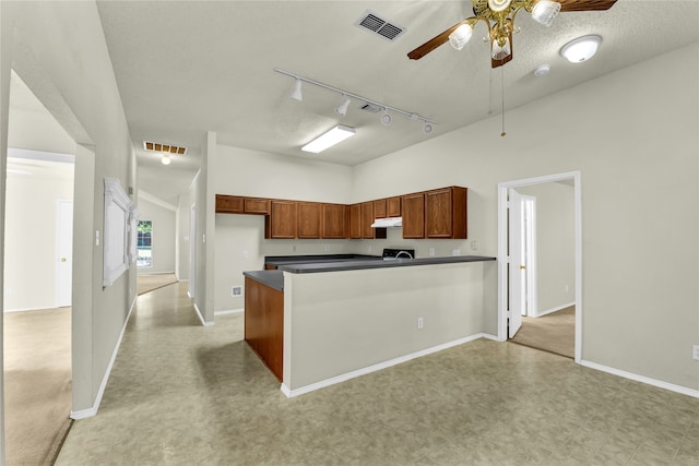 kitchen with light carpet, kitchen peninsula, rail lighting, a textured ceiling, and ceiling fan