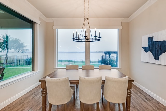 dining area with ornamental molding, a notable chandelier, and wood-type flooring