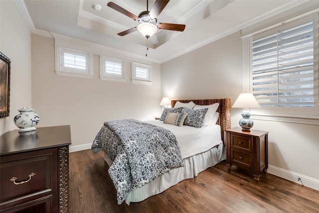 bedroom featuring dark wood-type flooring, crown molding, a tray ceiling, and ceiling fan