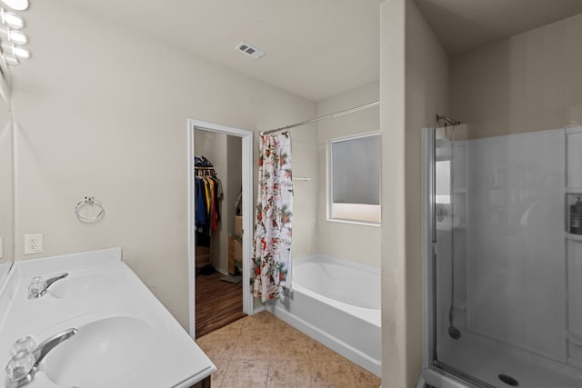 bathroom featuring vanity, shower with separate bathtub, and tile patterned flooring