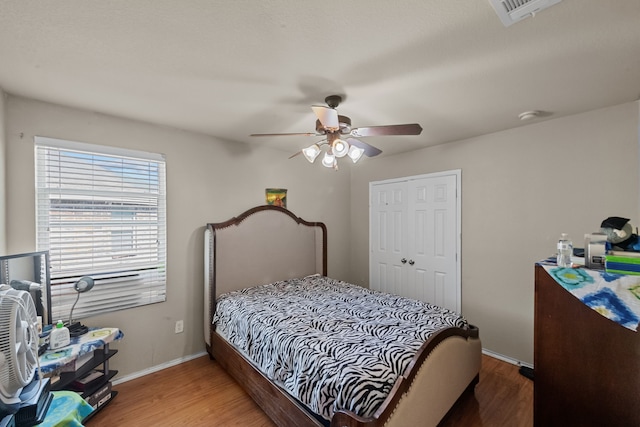 bedroom with hardwood / wood-style flooring, a closet, and ceiling fan