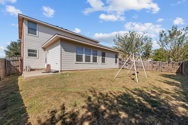 back of house with a patio, a lawn, and a playground