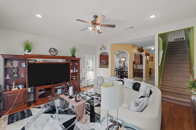 living room with ceiling fan, hardwood / wood-style flooring, and vaulted ceiling