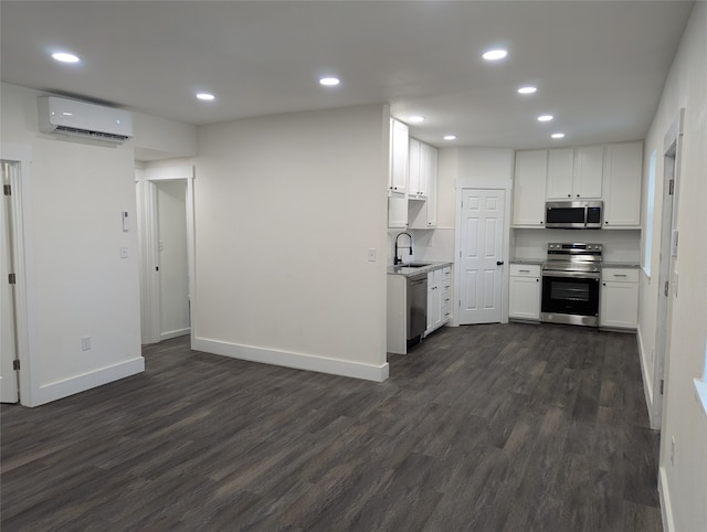 kitchen with white cabinets, a wall mounted air conditioner, dark hardwood / wood-style floors, sink, and stainless steel appliances