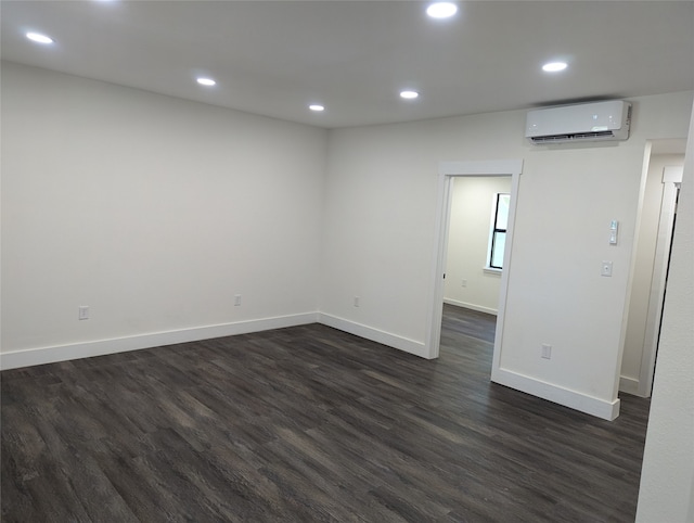 empty room with an AC wall unit and dark hardwood / wood-style flooring