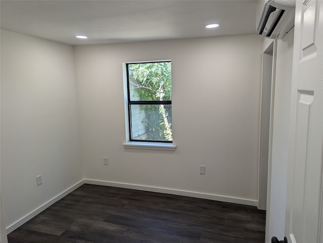 unfurnished room with dark wood-type flooring and a wall mounted air conditioner