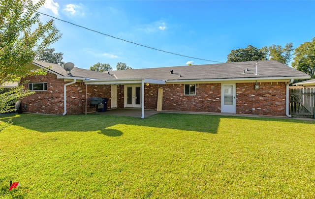 rear view of property featuring a patio and a lawn