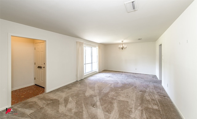 carpeted spare room with an inviting chandelier