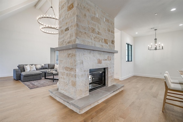 living room with beam ceiling, light hardwood / wood-style flooring, high vaulted ceiling, a notable chandelier, and a fireplace