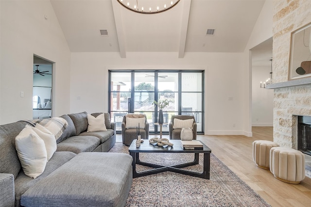 living room with ceiling fan, beamed ceiling, high vaulted ceiling, hardwood / wood-style floors, and a fireplace