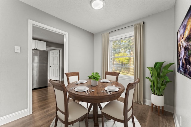 dining area with a textured ceiling and dark hardwood / wood-style floors