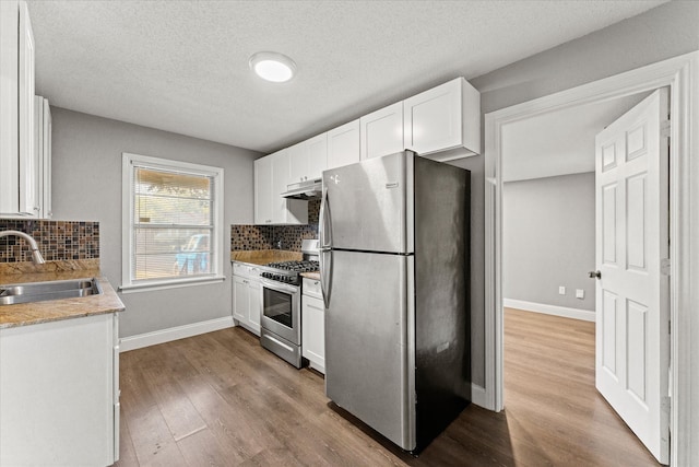 kitchen with decorative backsplash, sink, white cabinetry, and appliances with stainless steel finishes