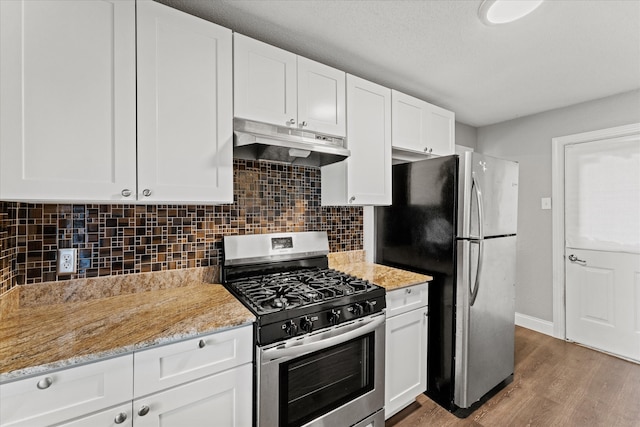 kitchen featuring hardwood / wood-style floors, stainless steel appliances, white cabinets, and light stone counters