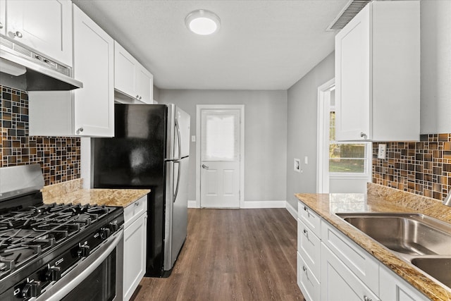 kitchen featuring decorative backsplash, white cabinets, stainless steel range with gas stovetop, and sink