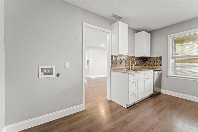 kitchen featuring decorative backsplash, stainless steel dishwasher, white cabinets, and sink