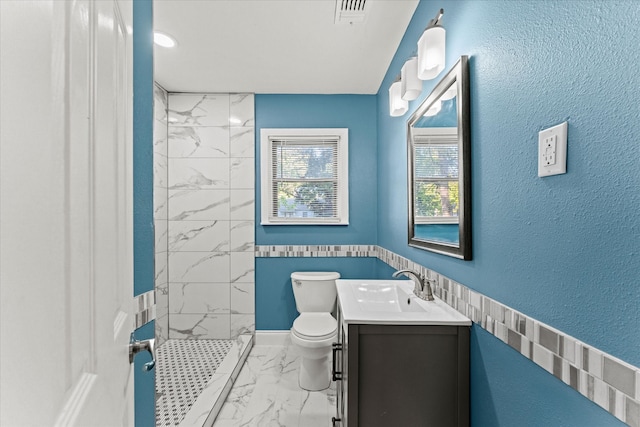 bathroom featuring vanity, toilet, and tiled shower