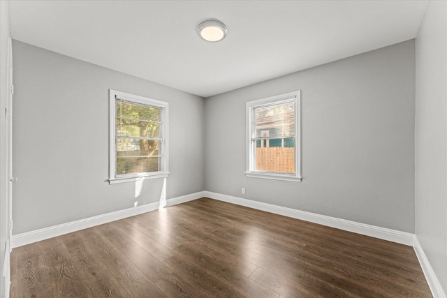 unfurnished room with dark hardwood / wood-style flooring