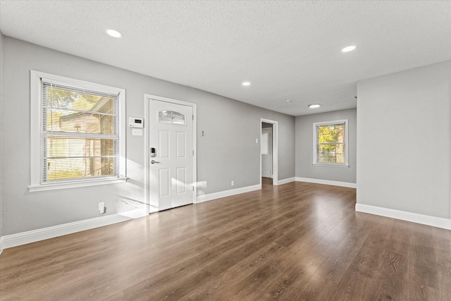 interior space featuring a wealth of natural light, dark hardwood / wood-style floors, and a textured ceiling