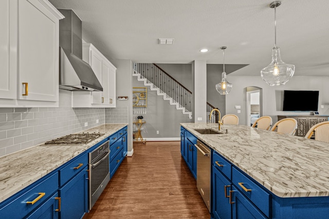 kitchen with a large island with sink, white cabinetry, dark hardwood / wood-style floors, sink, and blue cabinets