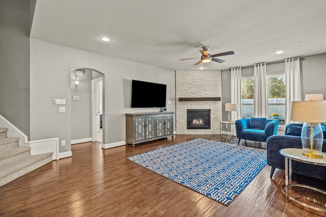 living room featuring ceiling fan, a fireplace, and hardwood / wood-style floors