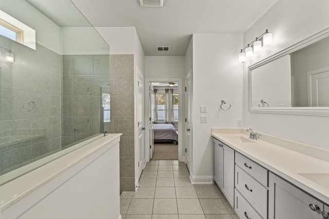 bathroom featuring vanity, a tile shower, and tile patterned floors