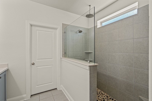 bathroom featuring vanity, tile patterned floors, and tiled shower