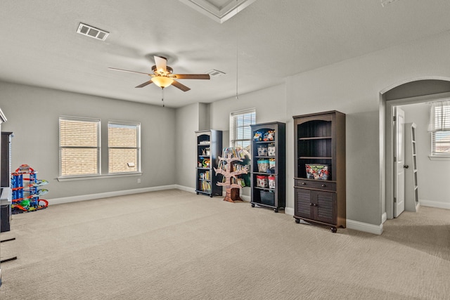 playroom with light carpet, a textured ceiling, and ceiling fan