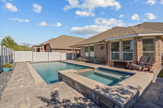 view of pool with a patio area and an in ground hot tub