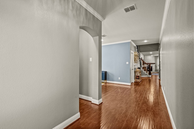 hallway with crown molding and hardwood / wood-style flooring