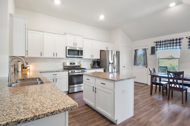 kitchen with dark hardwood / wood-style floors, stainless steel appliances, sink, a center island, and white cabinetry