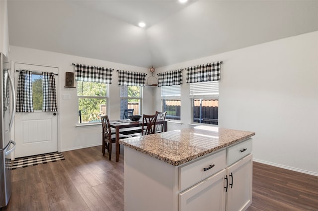 kitchen featuring light stone countertops, a center island, white cabinetry, vaulted ceiling, and dark hardwood / wood-style floors