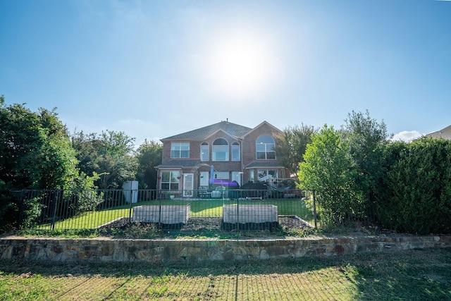 back of house with a yard and a fenced front yard