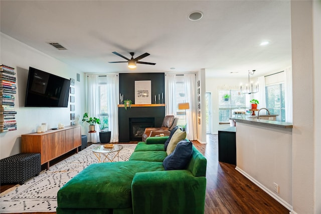 living room featuring wood-type flooring and ceiling fan with notable chandelier