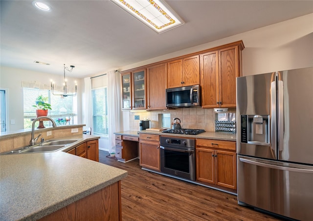 kitchen with sink, stainless steel appliances, dark hardwood / wood-style floors, a chandelier, and decorative light fixtures