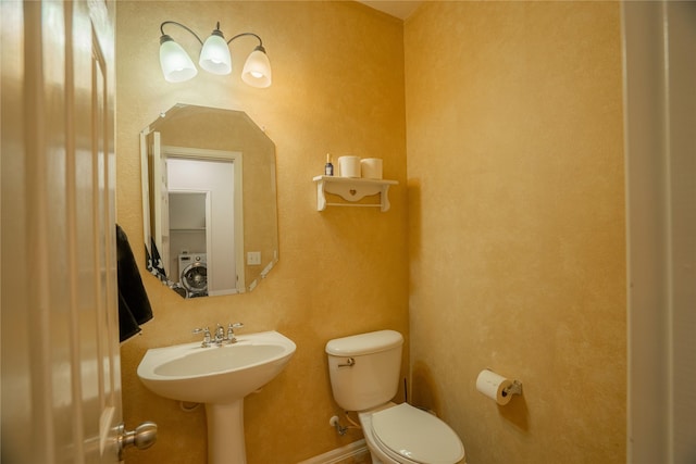 bathroom with washer / clothes dryer and toilet