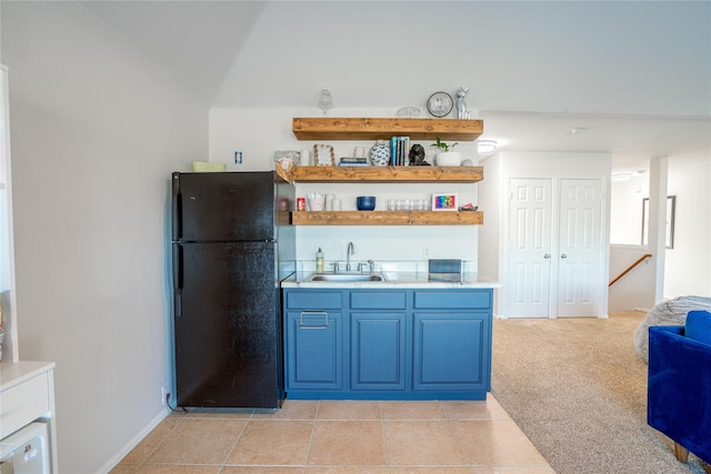 bar featuring black refrigerator, light colored carpet, blue cabinets, and sink