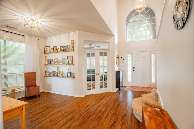 entrance foyer featuring hardwood / wood-style floors, an inviting chandelier, and french doors