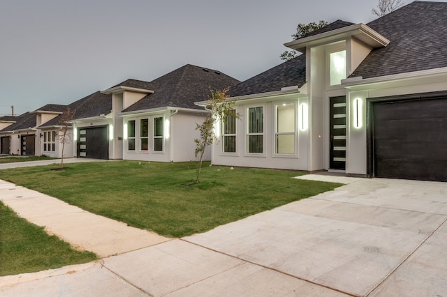 prairie-style house featuring a front yard and a garage