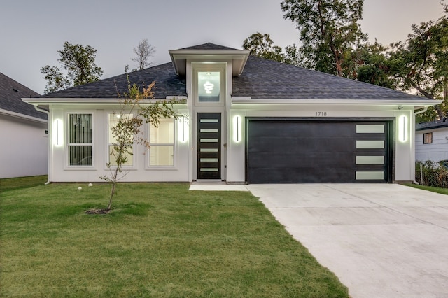 view of front of home with a yard and a garage