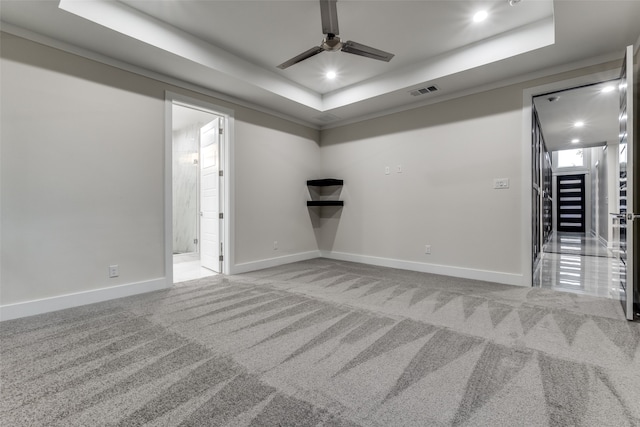 carpeted spare room featuring crown molding and a tray ceiling