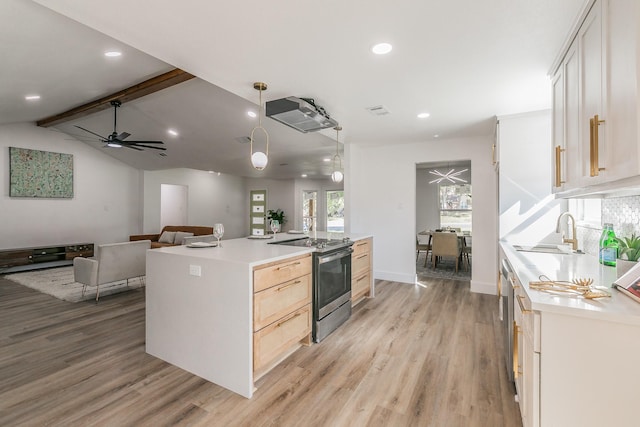 kitchen with stainless steel appliances, sink, decorative light fixtures, a center island, and light wood-type flooring