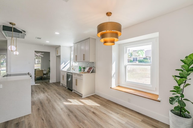 kitchen featuring light hardwood / wood-style floors, pendant lighting, and tasteful backsplash