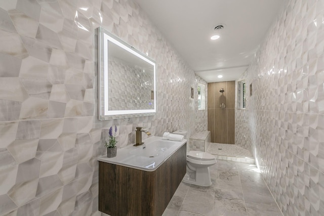 bathroom featuring tile walls, vanity, a shower, and toilet