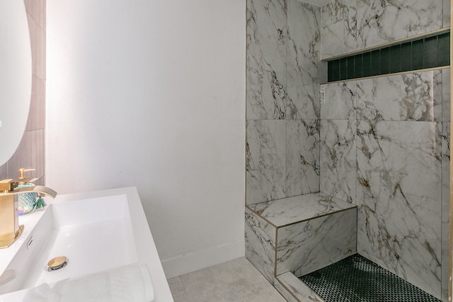 bathroom featuring sink, tiled shower, and tile patterned floors