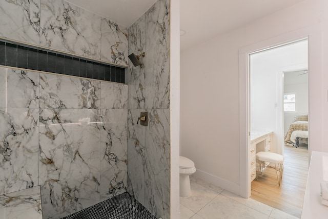 bathroom with a tile shower, tile patterned flooring, toilet, and vanity