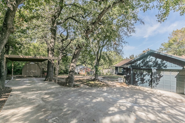 exterior space with a carport, a garage, and a storage shed