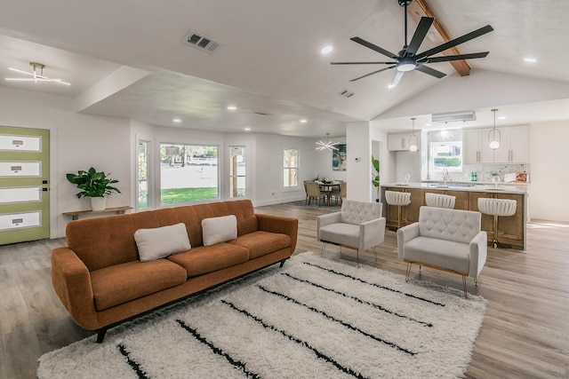 living room with sink, lofted ceiling with beams, ceiling fan, and light hardwood / wood-style floors