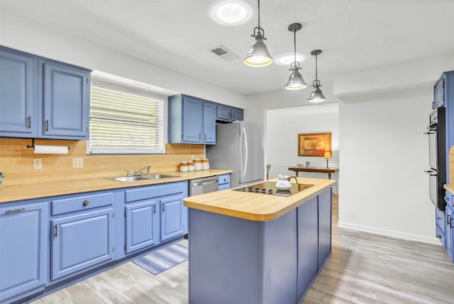 kitchen with wood counters, a center island, stainless steel appliances, decorative light fixtures, and blue cabinets