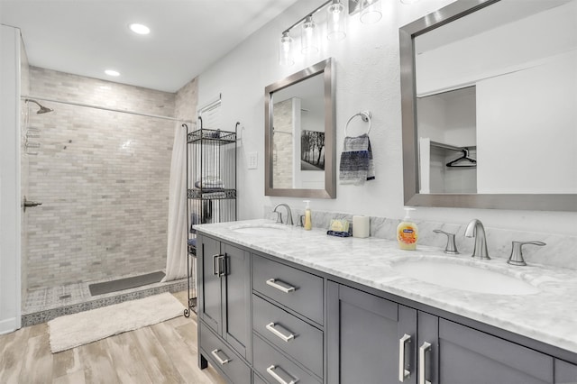 bathroom with vanity, wood-type flooring, and tiled shower